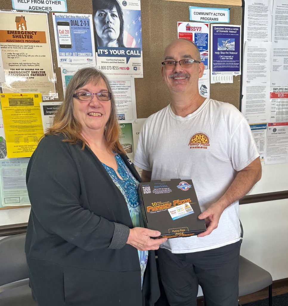 Healing starts with small acts of kindness. Punxsy Pizza’s Scott Anthony (R) donates pizza coupons to Suella Himes (L), Crossroads Director at Community Action, Inc. to brighten the day of domestic violence survivors in Jefferson County in honor of National Pizza Day on February 9. 